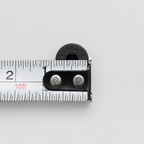 Black tapered flat-head L-track mounting screw shown across a tape measure to display the screw-head diameter.
