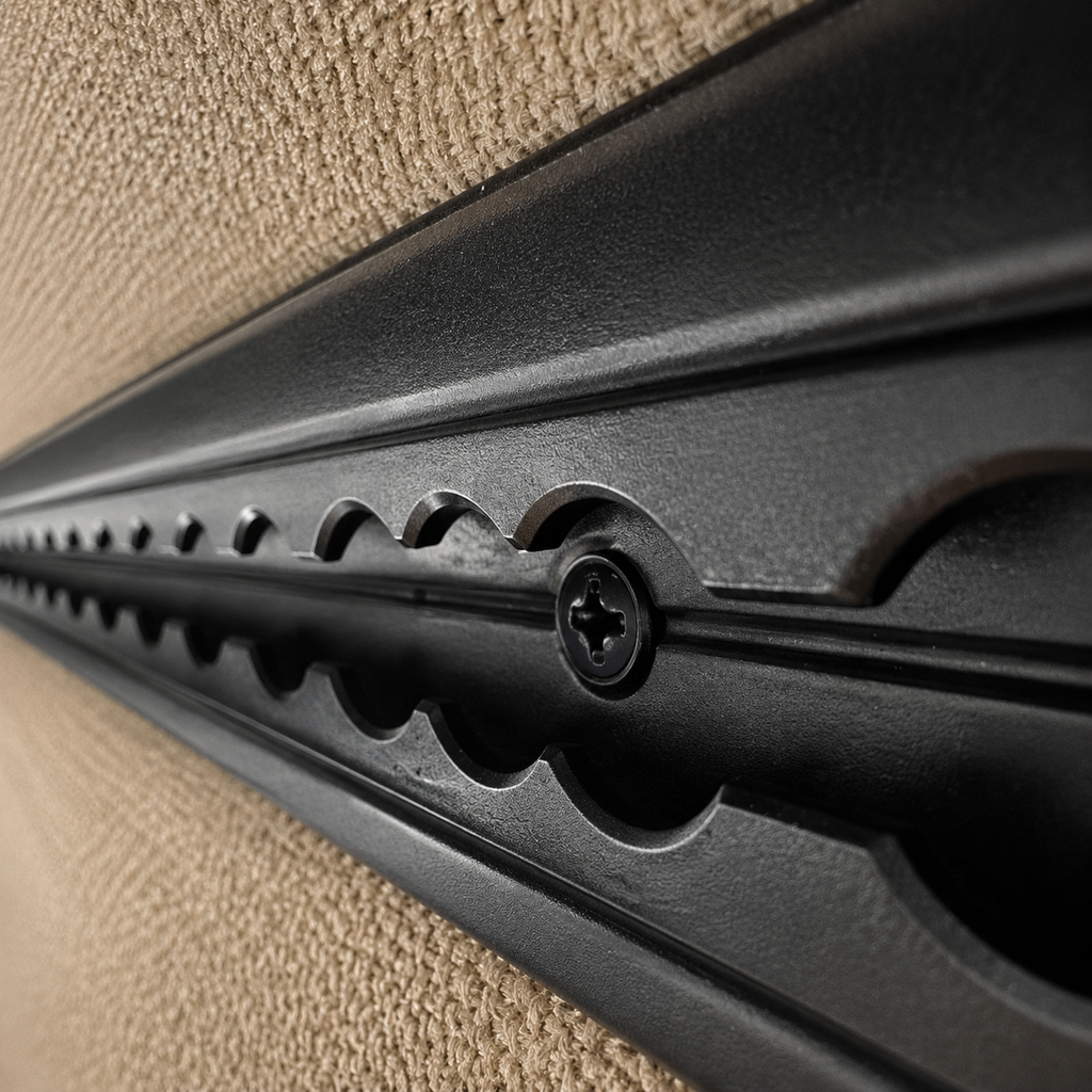 Black L-track mounting screw installed through L-track into van back framing